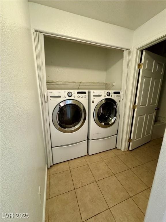 washroom with separate washer and dryer and light tile patterned floors