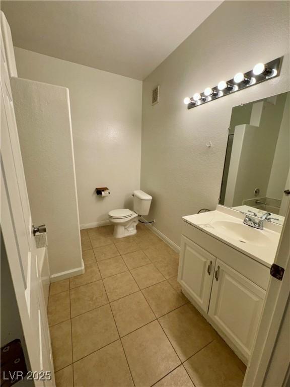 bathroom featuring tile patterned flooring, vanity, and toilet