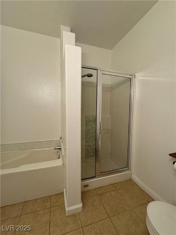 bathroom with tile patterned floors, shower with separate bathtub, and toilet