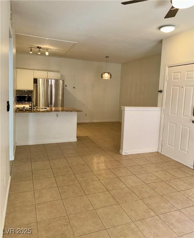 tiled spare room featuring sink and ceiling fan