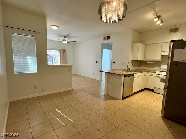 kitchen featuring sink, appliances with stainless steel finishes, white cabinetry, light tile patterned flooring, and kitchen peninsula