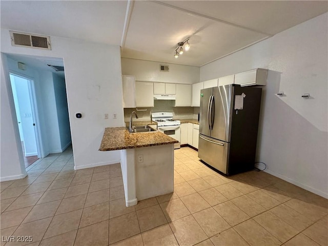 kitchen featuring stainless steel refrigerator, white cabinetry, white range with gas cooktop, and kitchen peninsula