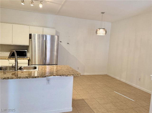 kitchen featuring sink, hanging light fixtures, dark stone countertops, stainless steel appliances, and white cabinets