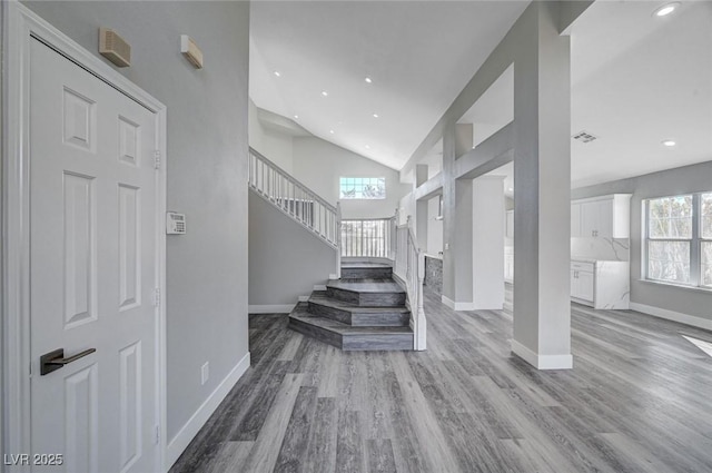 entryway featuring light wood-style floors, stairway, and a healthy amount of sunlight