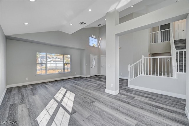 unfurnished living room featuring baseboards, wood finished floors, stairs, high vaulted ceiling, and recessed lighting