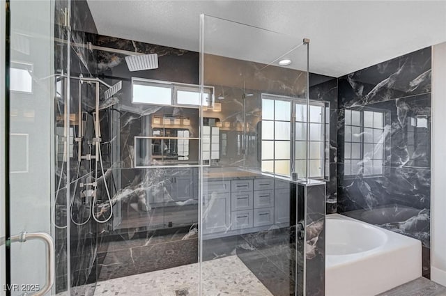 bathroom featuring marble finish floor, tile walls, a stall shower, vanity, and a bath