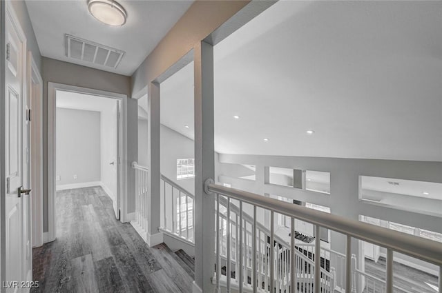 hall with dark wood-style floors, recessed lighting, visible vents, and baseboards