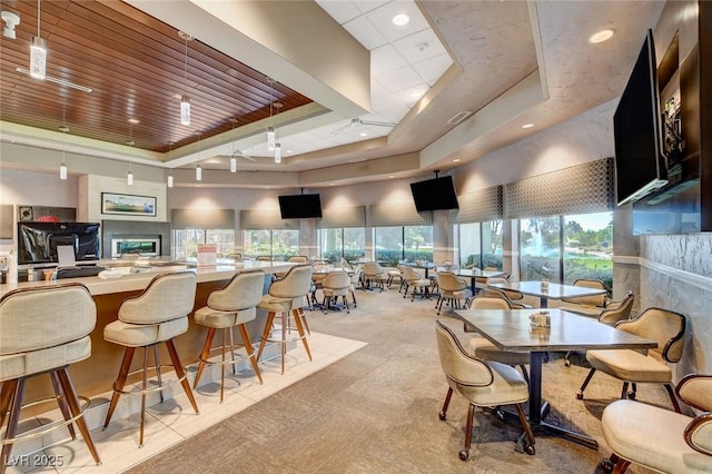 dining space with light carpet, a raised ceiling, and visible vents