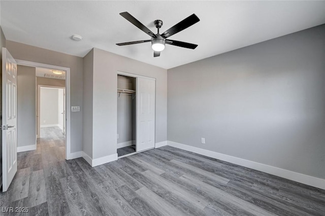 unfurnished bedroom featuring a closet, wood finished floors, and baseboards