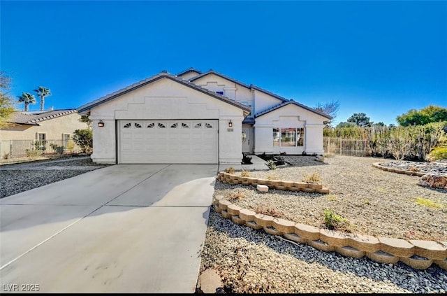 view of front of home featuring driveway, a garage, fence, and stucco siding