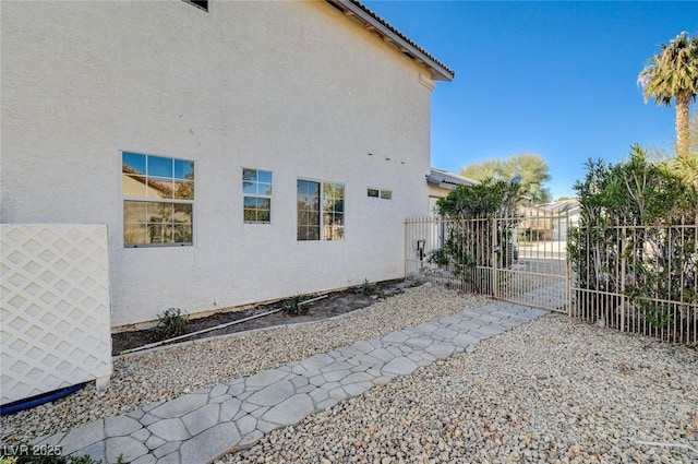 view of property exterior with fence and stucco siding