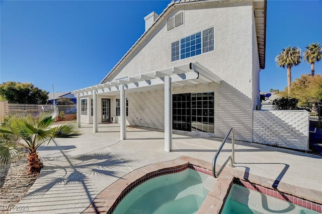 back of house with a patio, stucco siding, a pergola, fence, and an in ground hot tub