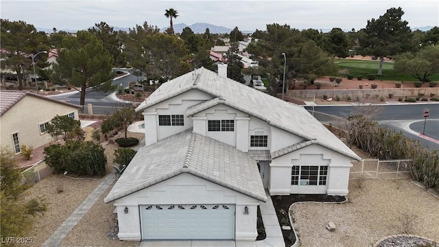 view of front of home featuring an attached garage, stucco siding, driveway, and a tiled roof