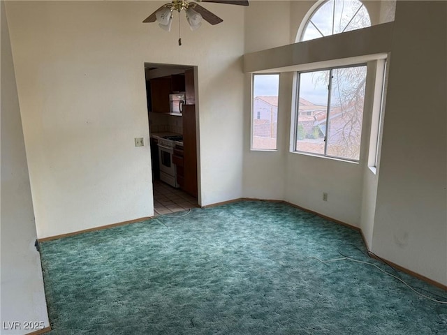 carpeted spare room featuring ceiling fan