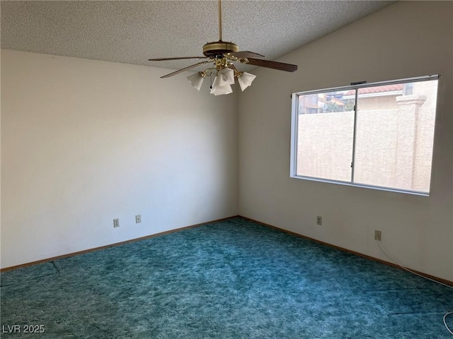 unfurnished room featuring dark colored carpet, lofted ceiling, ceiling fan, and a textured ceiling