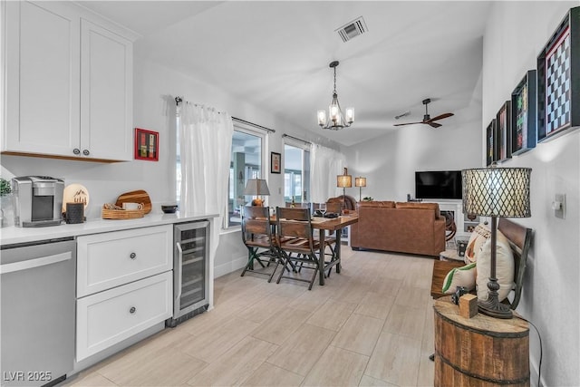 kitchen with ceiling fan with notable chandelier, dishwasher, white cabinets, wine cooler, and hanging light fixtures