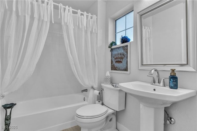 bathroom featuring shower / tub combo and toilet