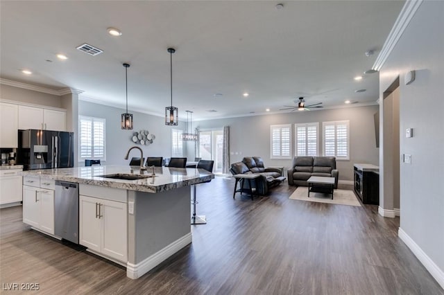 kitchen featuring white cabinetry, an island with sink, stainless steel appliances, and sink