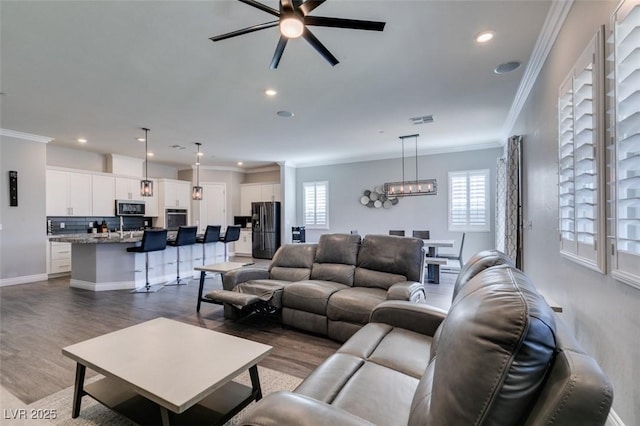 living room with crown molding, plenty of natural light, dark hardwood / wood-style floors, and ceiling fan