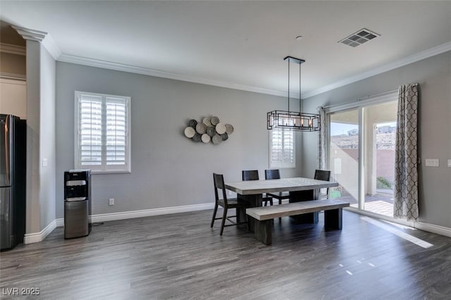 dining space with crown molding, plenty of natural light, and dark wood-type flooring