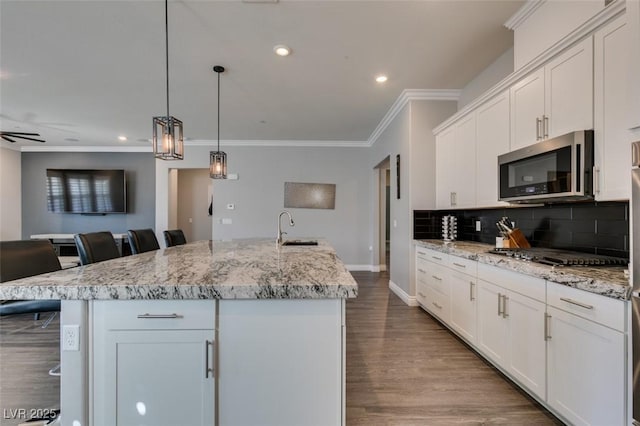 kitchen featuring appliances with stainless steel finishes, a kitchen island with sink, sink, and a kitchen breakfast bar