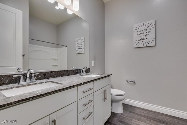 bathroom with vanity, a shower, hardwood / wood-style floors, and toilet