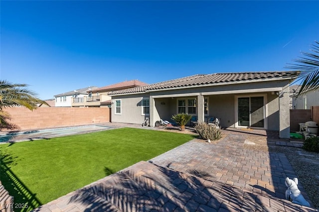 rear view of property featuring a yard and a patio area