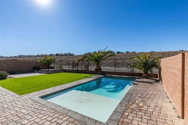 view of pool featuring a lawn