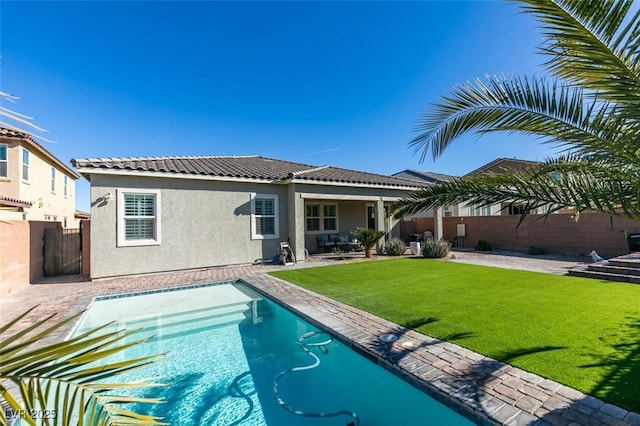 view of pool with a patio and a lawn