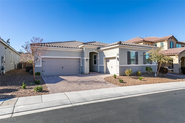 mediterranean / spanish-style house with a garage and central AC