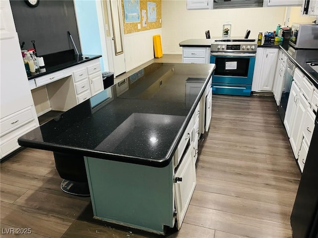 kitchen featuring stainless steel appliances, dark hardwood / wood-style floors, white cabinets, and a kitchen island