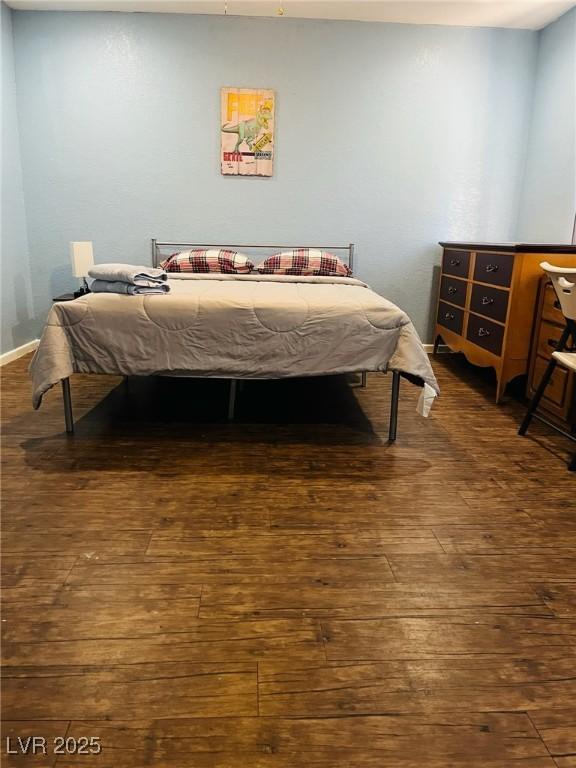 bedroom with dark hardwood / wood-style flooring