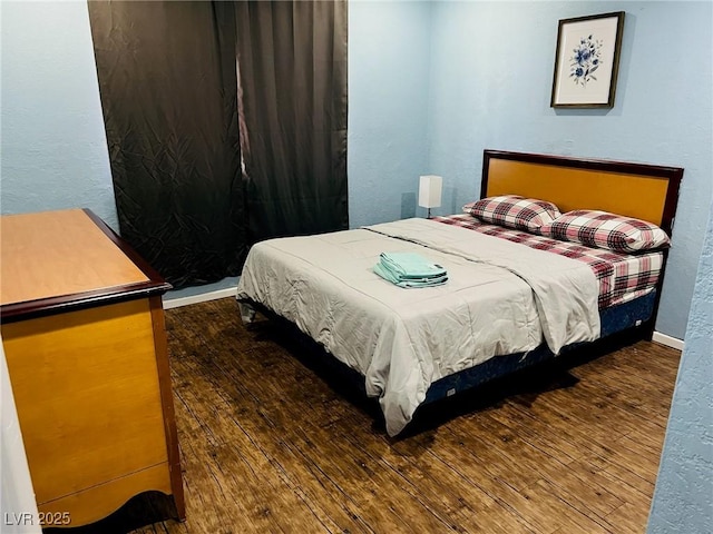 bedroom with dark hardwood / wood-style floors