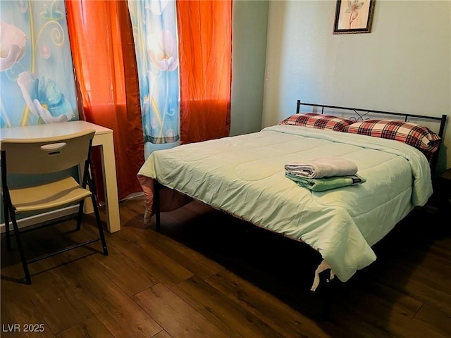 bedroom with dark hardwood / wood-style floors