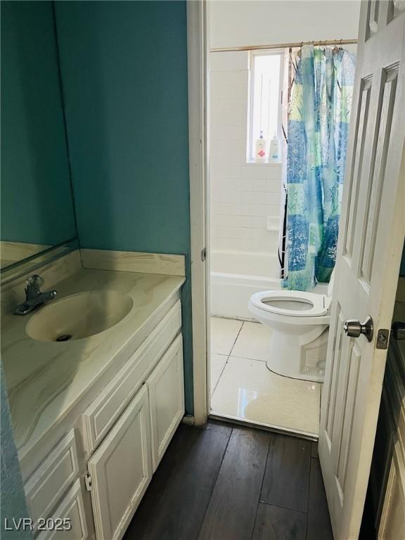 full bathroom featuring vanity, toilet, wood-type flooring, and shower / bath combo