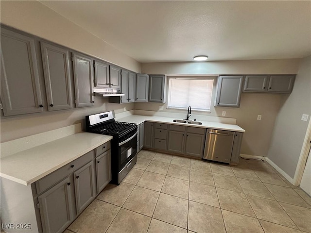 kitchen with appliances with stainless steel finishes, sink, and gray cabinetry