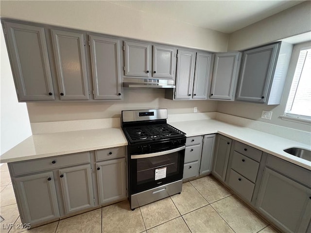 kitchen with gray cabinets, sink, light tile patterned floors, and stainless steel gas stove