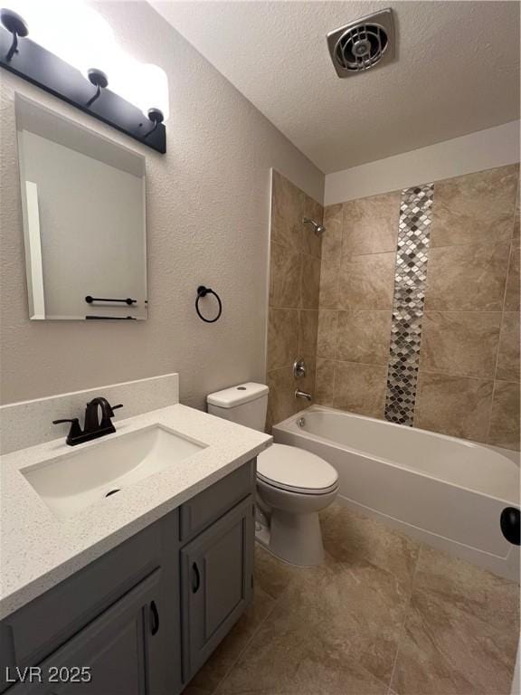 full bathroom with tiled shower / bath combo, vanity, a textured ceiling, and toilet