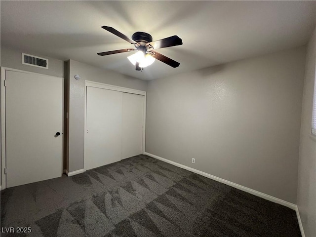 unfurnished bedroom featuring a closet, ceiling fan, and dark colored carpet