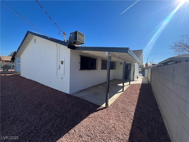 view of property exterior with cooling unit and a patio