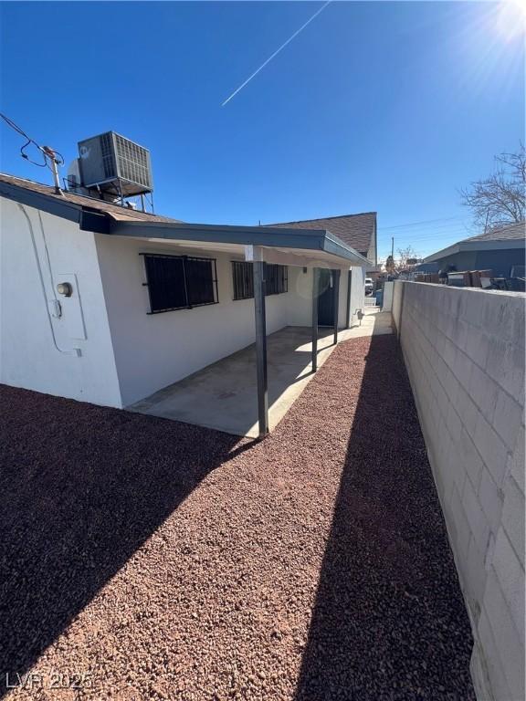 view of side of property featuring a patio and central AC unit