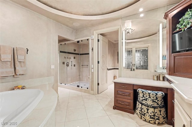 bathroom featuring tile patterned flooring, vanity, plus walk in shower, and a tray ceiling