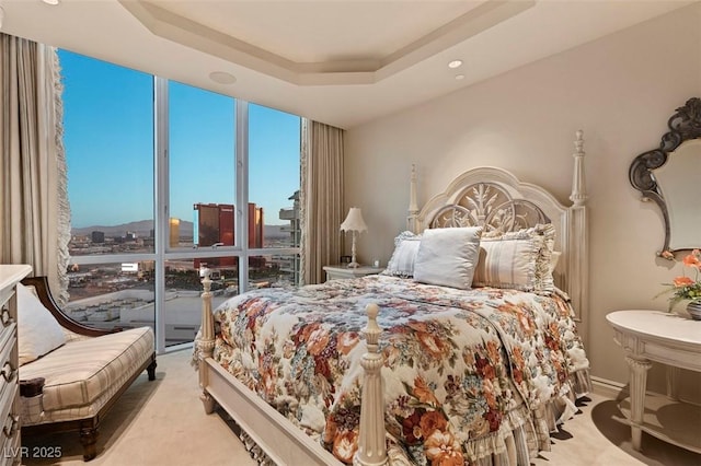 bedroom featuring expansive windows, light carpet, access to exterior, and a tray ceiling