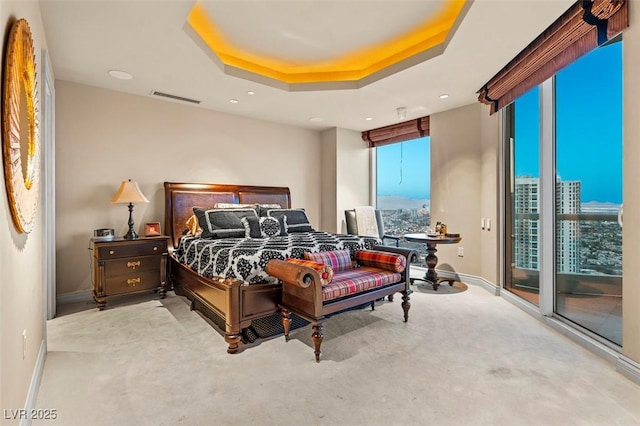 bedroom featuring a raised ceiling and access to outside