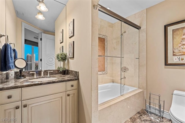 full bathroom with vanity, toilet, and combined bath / shower with glass door