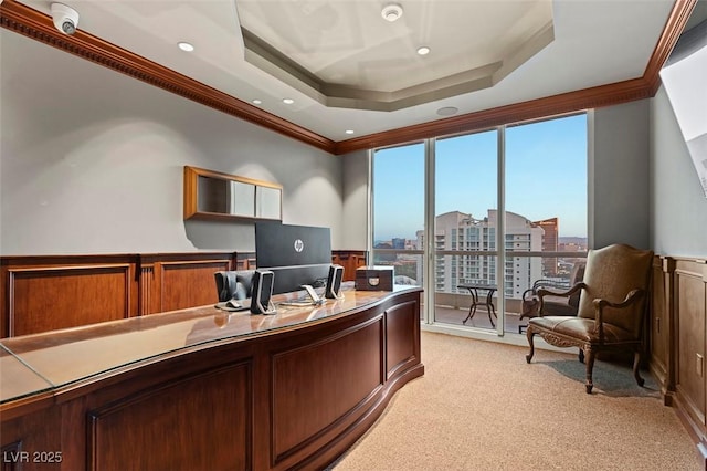 office space with ornamental molding, a tray ceiling, and light carpet