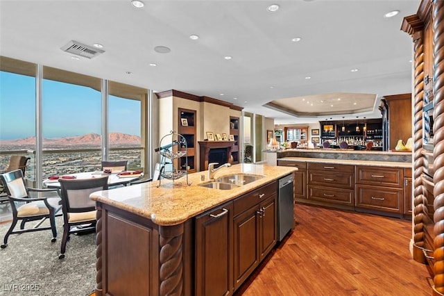 kitchen featuring sink, dark hardwood / wood-style floors, a center island with sink, a mountain view, and stainless steel dishwasher