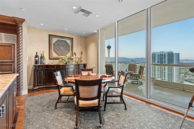 dining room featuring a wall of windows, dark hardwood / wood-style floors, and a mountain view