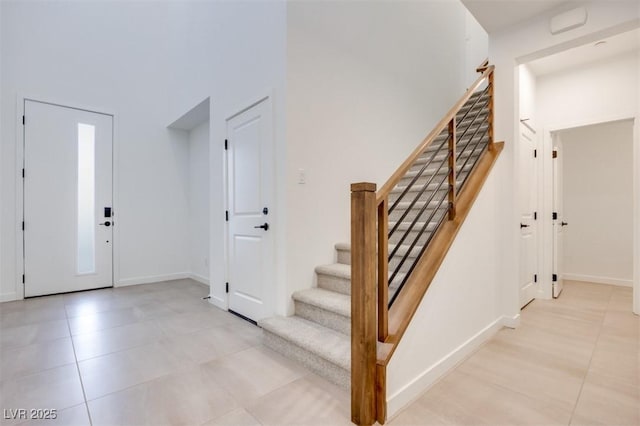 entrance foyer featuring light tile patterned floors and a towering ceiling