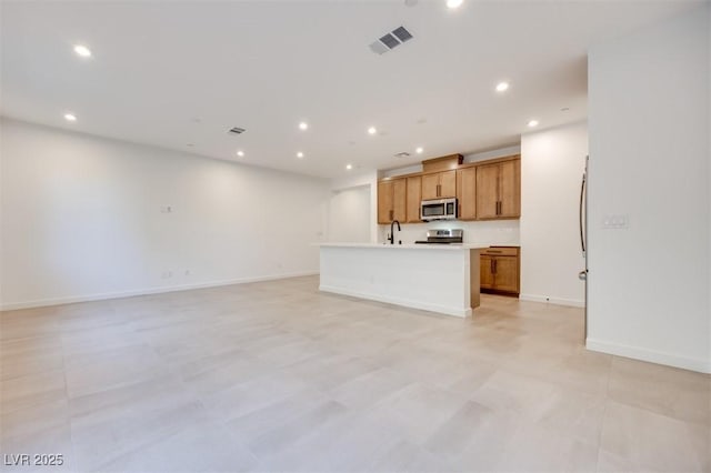 kitchen featuring an island with sink and sink